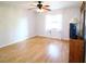 Bedroom with laminate flooring, ceiling fan, window with curtain panels and views of the backyard at 5351 Sw 80Th Pl, Ocala, FL 34476