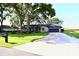 Inviting brick home with a well-manicured lawn, mature trees, and a long driveway at 5351 Sw 80Th Pl, Ocala, FL 34476