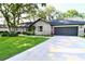 Charming brick home featuring a lush lawn, mature trees and a two-car garage at 5351 Sw 80Th Pl, Ocala, FL 34476