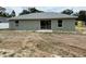 Backyard view features the home's neutral exterior paint and sliding glass doors at 5359 Nw 55Th Pl, Ocala, FL 34482