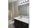 Bathroom featuring a shower with tan covering and a dark vanity with a white countertop at 5359 Nw 55Th Pl, Ocala, FL 34482