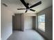 This bedroom has tile floors, a ceiling fan, a large window, and closet space at 5359 Nw 55Th Pl, Ocala, FL 34482