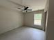 Bright bedroom with tile floors, ceiling fan, and a large window overlooking the property at 5359 Nw 55Th Pl, Ocala, FL 34482