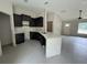 Well-lit kitchen with dark cabinets, light countertops, and open access to the living area at 5359 Nw 55Th Pl, Ocala, FL 34482