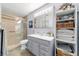 Well-lit bathroom featuring a glass shower, vanity with drawers, and built-in shelving for towels and toiletries at 5521 Sw 31St St, Ocala, FL 34474