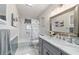 A clean bathroom with white marble countertop, gray cabinetry, and a bathtub shower combination at 5521 Sw 31St St, Ocala, FL 34474