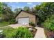 Exterior view of the detached garage with white door, walkway, and landscaping at 5521 Sw 31St St, Ocala, FL 34474