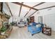 Bright living room featuring a stone fireplace, exposed beams, and comfortable seating arrangements at 5521 Sw 31St St, Ocala, FL 34474