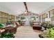Inviting sun room filled with plants and comfortable seating, featuring wood-look floors and ample natural light at 5521 Sw 31St St, Ocala, FL 34474