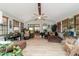 Bright sun room with wood flooring, multiple seating areas, plants and an open doorway to another room at 5521 Sw 31St St, Ocala, FL 34474