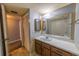 Bathroom includes a vanity with wood cabinets and a sink, a closet with louvered doors, and a mirrored wall at 559 Fairway Circle # A, Ocala, FL 34472