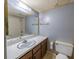 Modest bathroom vanity area with a sink, wood cabinets, a standard toilet, and mirrored wall at 559 Fairway Circle # A, Ocala, FL 34472
