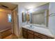 Bathroom includes a vanity with wood cabinets and a sink, a closet with louvered doors, and a mirrored wall at 559 Fairway Circle # A, Ocala, FL 34472