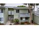 Two-story condo with light-green exterior, stairs to the second floor, and mature trees surrounding the property at 559 Fairway Circle # A, Ocala, FL 34472