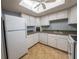 Bright kitchen featuring white cabinetry and appliances, and a skylight illuminating the space at 559 Fairway Circle # A, Ocala, FL 34472