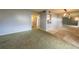 Open living room layout featuring carpeted and bare floors leading to hallway and kitchen at 559 Fairway Circle # A, Ocala, FL 34472
