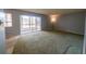 Spacious living room features carpet and sliding glass doors to screened patio at 559 Fairway Circle # A, Ocala, FL 34472