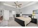 A well-lit bedroom showcases a tray ceiling, fan, and a full ensuite bathroom, providing convenience and privacy at 5862 Sw 80Th Ln, Ocala, FL 34476
