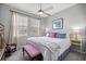 Comfortable bedroom features a ceiling fan, two windows, and a queen-size bed with decorative pillows at 5862 Sw 80Th Ln, Ocala, FL 34476