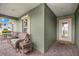 Inviting front porch with wicker furniture, brick pavers, and glass front door at 6436 Sw 44Th Ct, Ocala, FL 34474