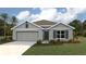 Charming single-story home featuring a two-car garage, well-manicured lawn, and tropical landscaping at 7101 Se 113Th Ln, Belleview, FL 34420