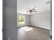 Bright bedroom featuring wood-look floors, a modern ceiling fan, and a large window with a serene outdoor view at 7483 Sw 121St Ter, Dunnellon, FL 34432