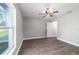 Bright, airy bedroom with wood-look flooring, a modern ceiling fan, and large windows providing plenty of natural light at 7483 Sw 121St Ter, Dunnellon, FL 34432