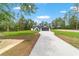 Attractive single-story home with a long driveway, black garage door, and expansive green lawn at 7483 Sw 121St Ter, Dunnellon, FL 34432