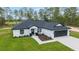 Home featuring an attached two-car garage, black accents and a manicured lawn at 7483 Sw 121St Ter, Dunnellon, FL 34432