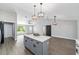 Spacious kitchen with a center island, modern lighting, and views of the open-concept living area at 7483 Sw 121St Ter, Dunnellon, FL 34432