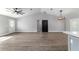 Open-concept living space with vaulted ceiling, wood-look floors, and modern light fixture at 7483 Sw 121St Ter, Dunnellon, FL 34432