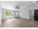 Bright living room featuring vaulted ceilings, wood-look flooring, and a stylish sliding barn door at 7483 Sw 121St Ter, Dunnellon, FL 34432
