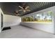 Spacious covered patio with ceiling fans, a black-painted wood ceiling, and tranquil views of the wooded backyard at 7483 Sw 121St Ter, Dunnellon, FL 34432