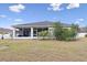 Backyard showing screened patio, trees and grass at 808 Overlook Grove Dr, Winter Haven, FL 33884