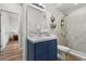 Bathroom with tiled shower, decorative wall baskets, and a blue vanity at 808 Overlook Grove Dr, Winter Haven, FL 33884