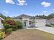 Charming single-story home with neutral stucco exterior, manicured lawn, and attached two-car garage, framed by lush landscaping at 808 Overlook Grove Dr, Winter Haven, FL 33884