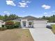 Charming single-story home featuring a well-manicured lawn, a two-car garage, and beautiful landscaping at 808 Overlook Grove Dr, Winter Haven, FL 33884