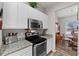 Kitchen area with stainless steel oven and microwave, granite countertops, and sleek white cabinets at 808 Overlook Grove Dr, Winter Haven, FL 33884