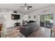Spacious living room with tile flooring, ceiling fan, TV, and sliding glass doors to the outdoor patio at 808 Overlook Grove Dr, Winter Haven, FL 33884