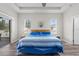 Bright primary bedroom featuring a tray ceiling, neutral walls, wood-look flooring, and direct access to lanai at 808 Overlook Grove Dr, Winter Haven, FL 33884