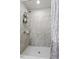 Walk-in shower featuring gray tile, built-in shelving, and a patterned shower curtain at 808 Overlook Grove Dr, Winter Haven, FL 33884