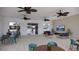 Community common room with seating areas, ceiling fans, a wall-mounted television, and exterior views at 8578 Pinecrest Trl, Wildwood, FL 34785