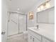 Renovated bathroom with glass-enclosed shower, white vanity, and marble-look tile at 8712 Sw 92Nd St # C, Ocala, FL 34481