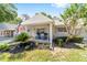 Charming single-story home with mature landscaping, an American flag, an attached garage, and front porch seating at 8712 Sw 92Nd St # C, Ocala, FL 34481