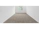 Empty bedroom showing neutral colored carpet, white walls, and a large window at 8783 Sw 69Th Place Rd, Ocala, FL 34481