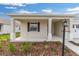 Inviting front porch featuring stylish columns, manicured landscaping and eye-catching lamp post at 8783 Sw 69Th Place Rd, Ocala, FL 34481