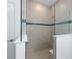 Beautiful tiled walk-in shower with glass partition and decorative tile accent at 8783 Sw 69Th Place Rd, Ocala, FL 34481