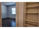 Neutral bedroom featuring wood-look floors, natural light, and a built-in storage bookcase at 9 Pine Radial Ct, Ocala, FL 34472