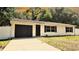 Inviting single-story house featuring a convenient attached garage and a freshly sealed driveway at 9 Pine Radial Ct, Ocala, FL 34472
