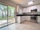 Sunlit kitchen with white cabinets, stainless steel appliances, and backyard access at 9 Pine Radial Ct, Ocala, FL 34472